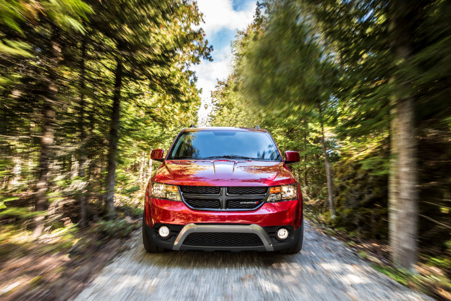 Front view of red pre-owned Dodge Journey in Canadian woods