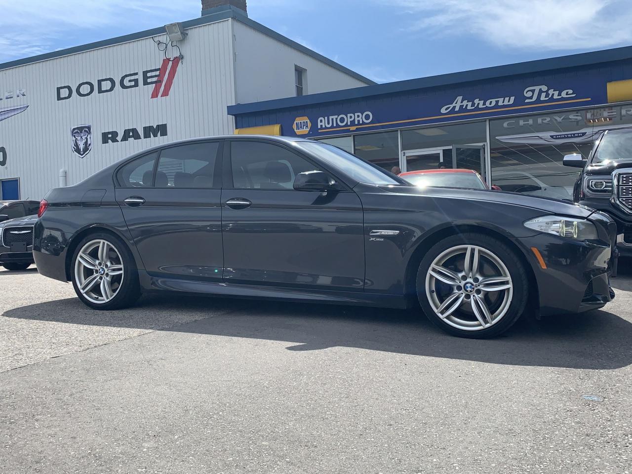 Gray BMW sedan parked outside Arrow Tire in Canada