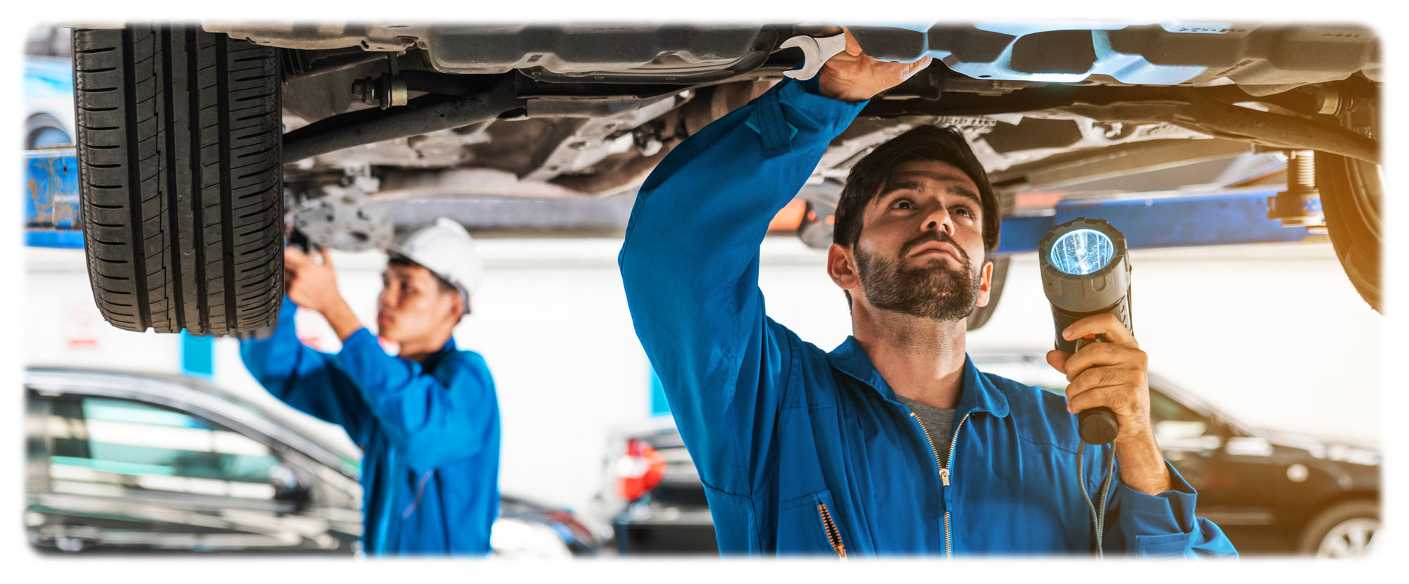 Man in blue shirt working on car at certified CPO repair and maintenance centre in Canada