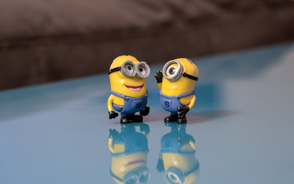 Two Minion figurines from the film "Despicable Me" arranged on a table