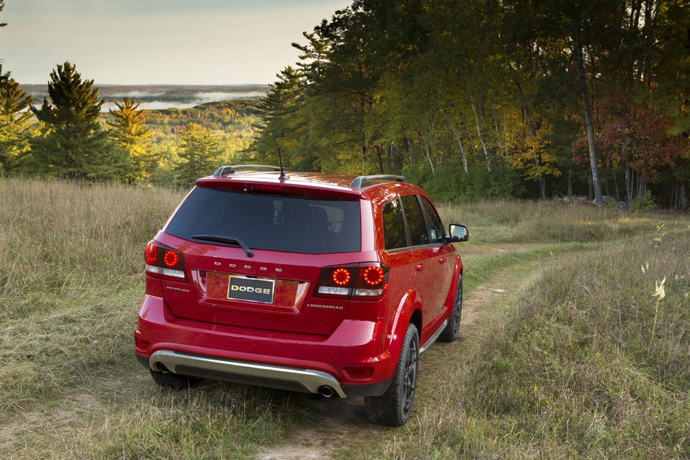 Rear of red Dodge Journey in grassy plain in Canada