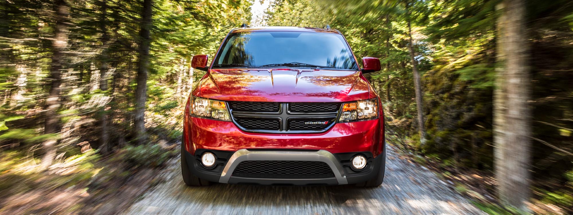 Red Dodge Journey in wooded area in Canada