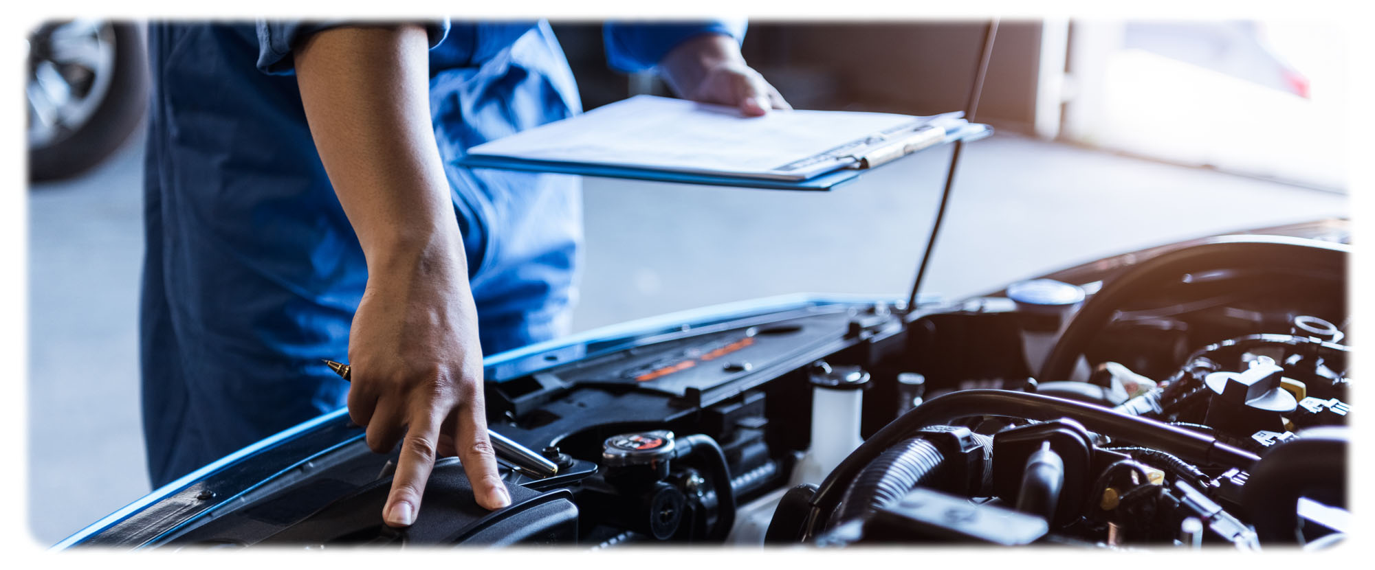 Man in blue shirt working on car engine at certified service centre in Canada